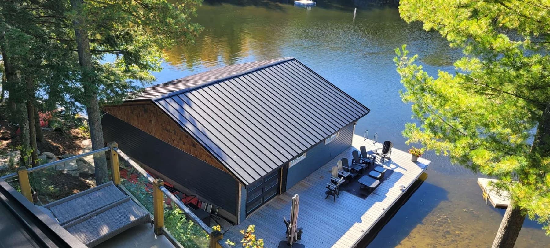 Dark standing seam roof on a timber boathouse beside the lake