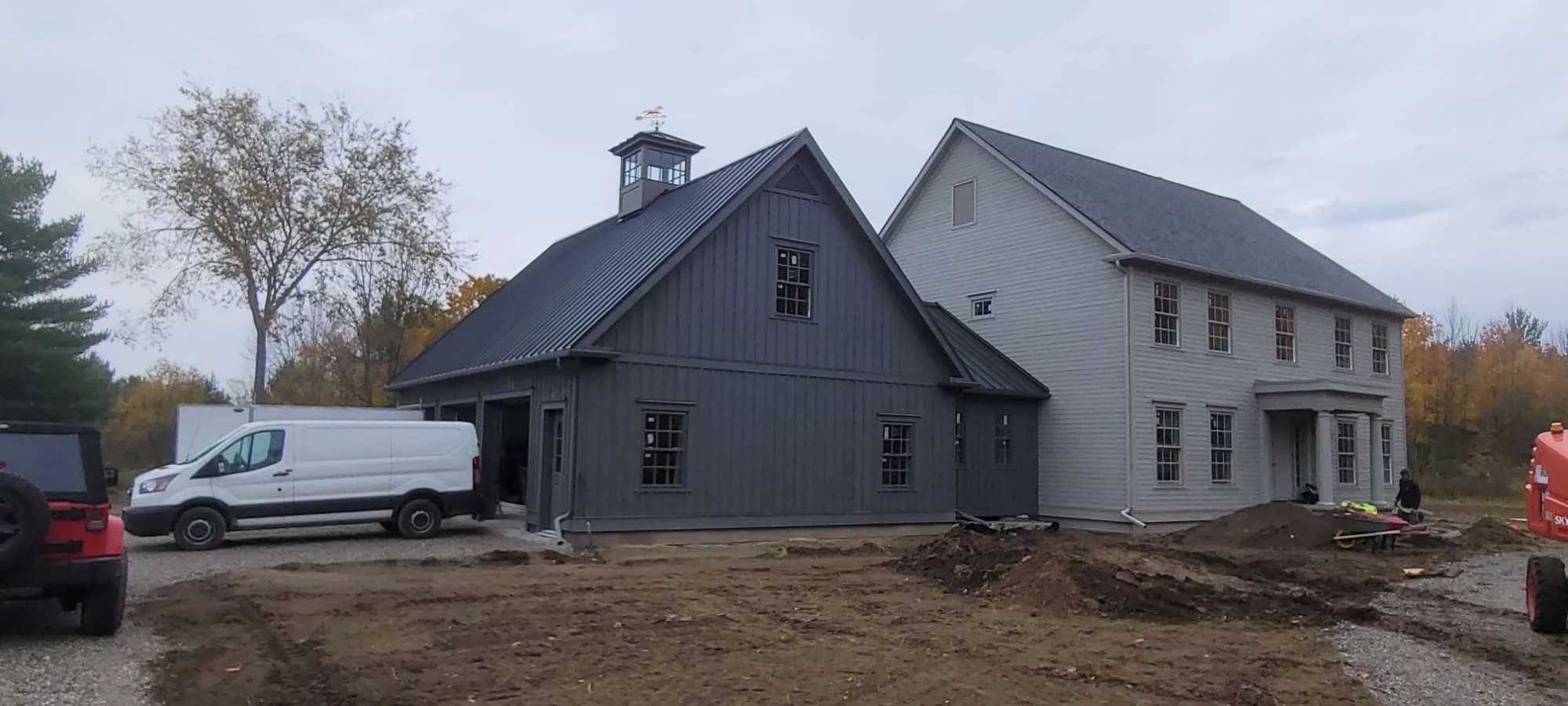 House and attached garage with a metal roof and cupola during construction