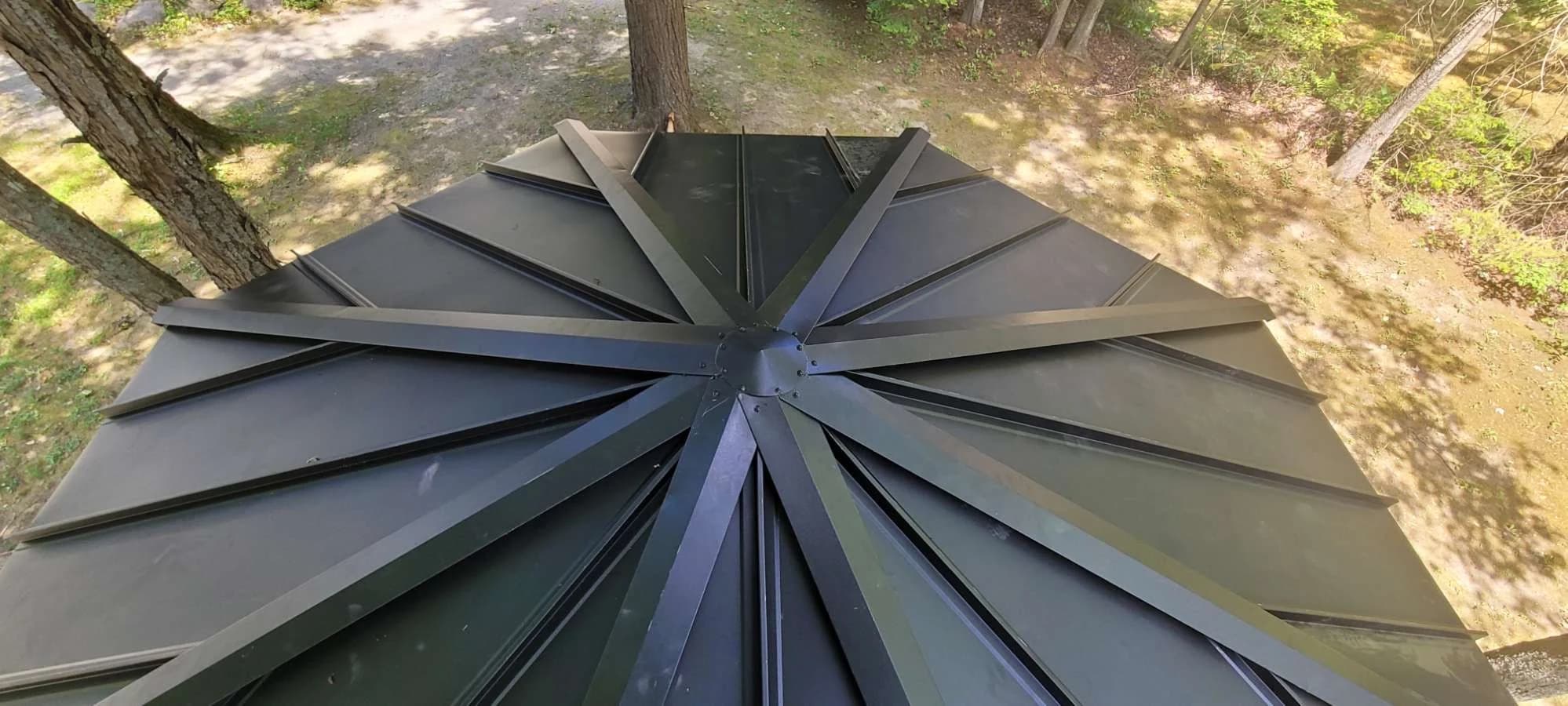 Multiple standing seam roof hips meeting at a central point
