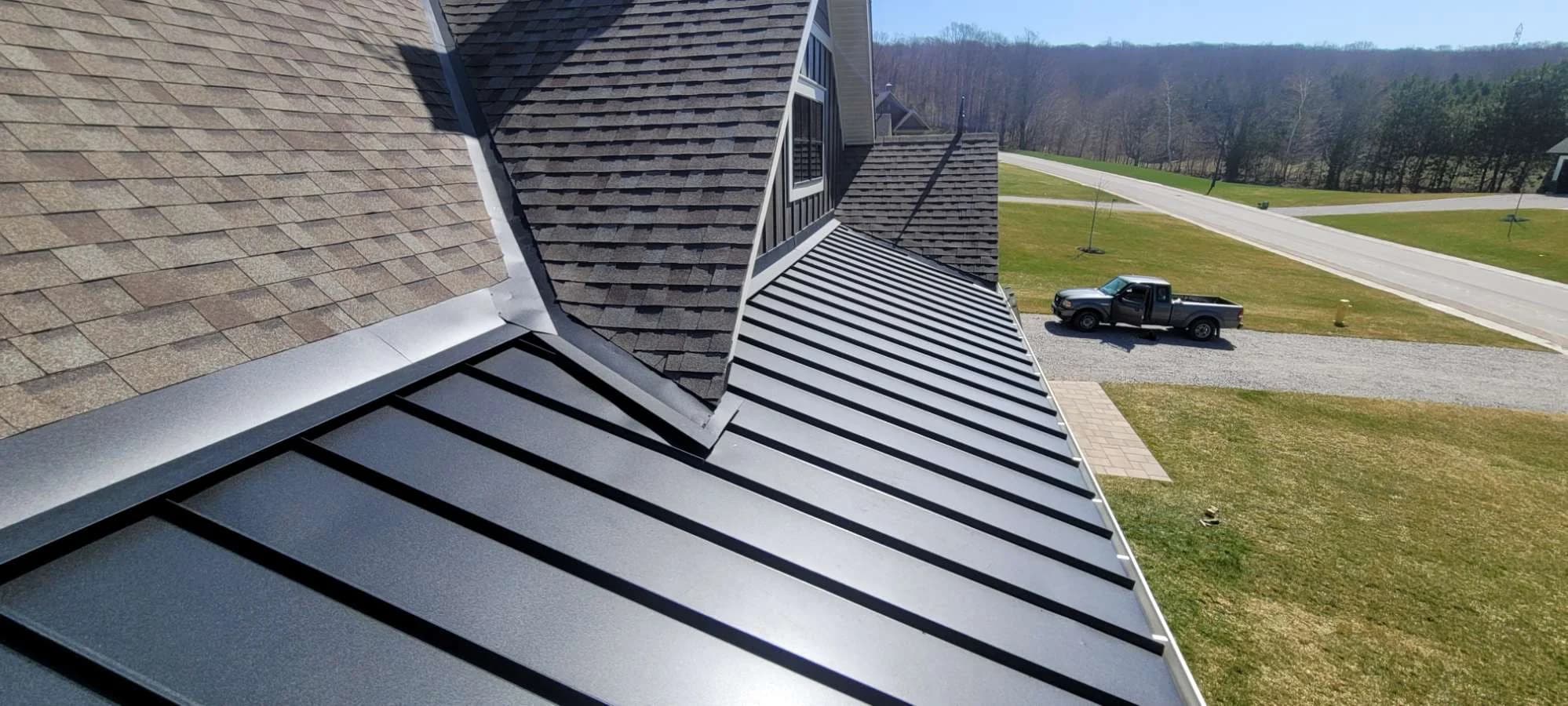 Standing seam roof running alongside a brick wall
