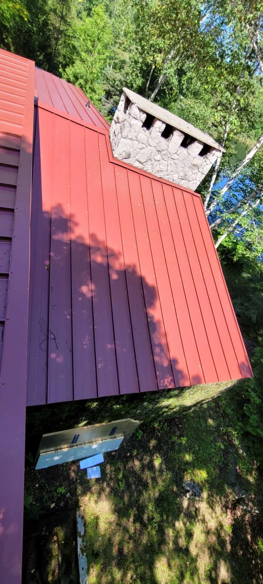 Portrait view of a red metal roof and chimney