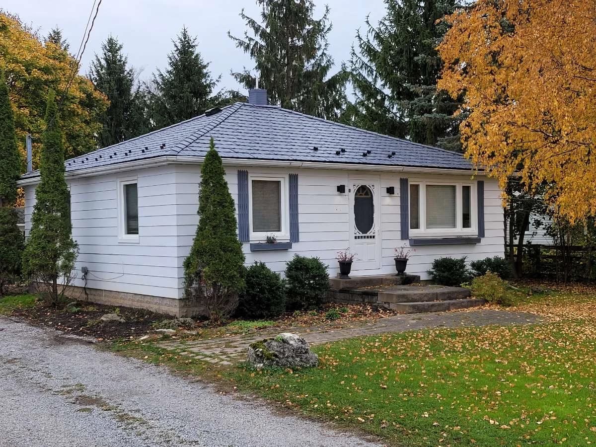 Metal roof on a small white cottage among autumn trees