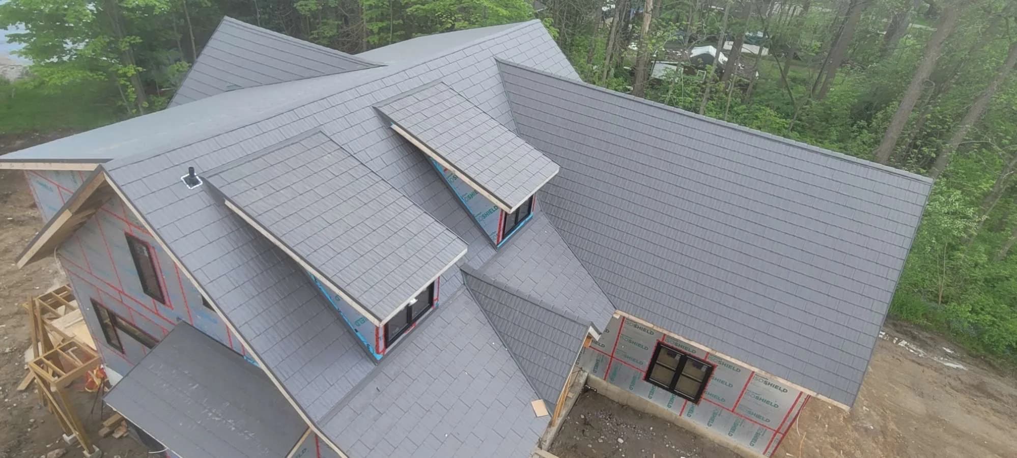 Angled aerial view of a metal shingle roof with dormers