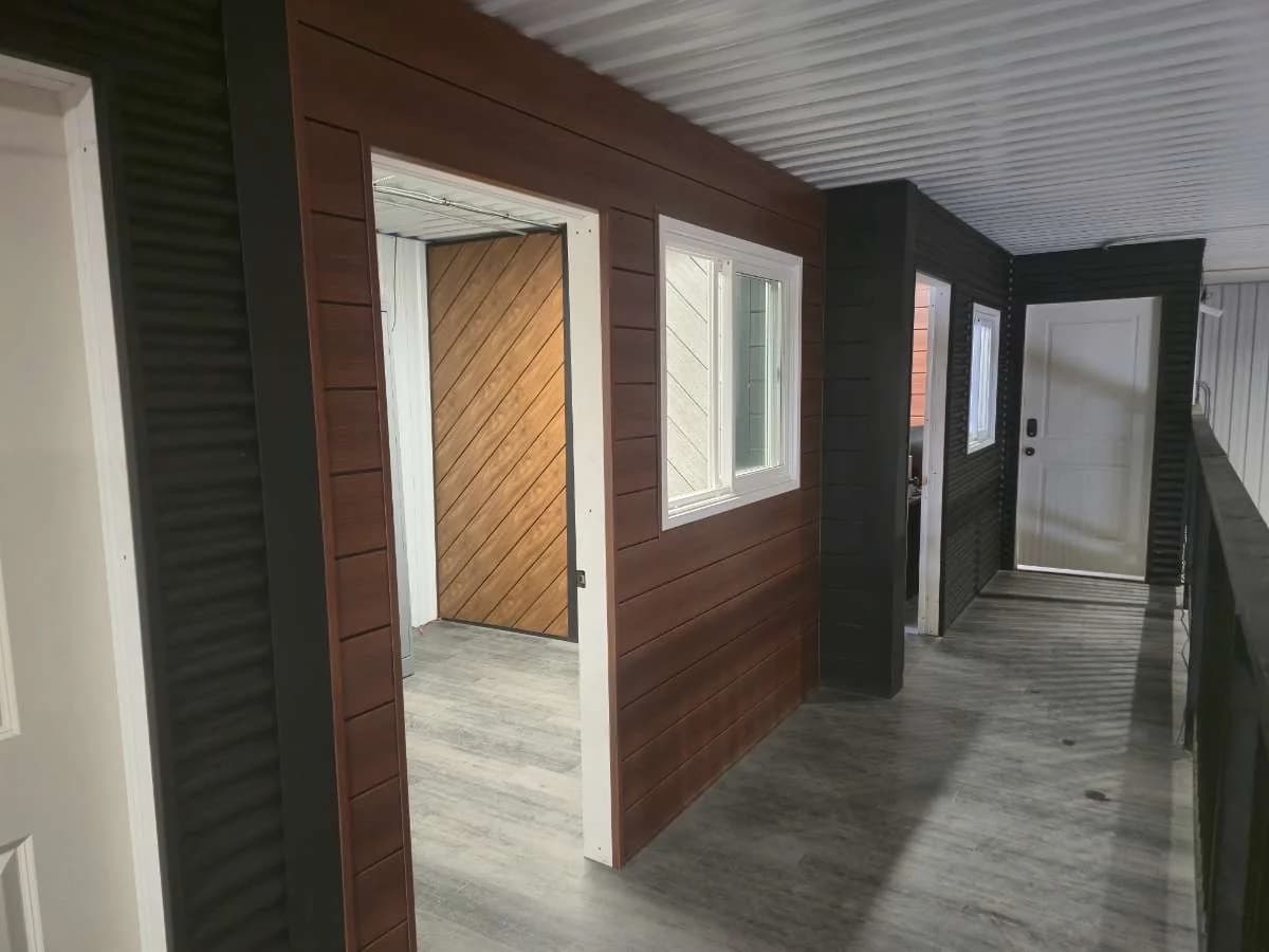 Wood-look and dark metal siding beneath a covered porch